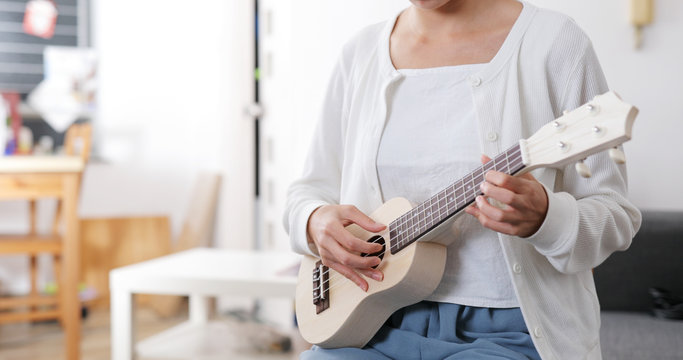 Woman play a music on ukulele