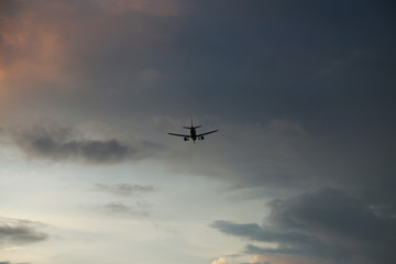 Fototapeta na wymiar The airplane is flying against the blue sky in the sun