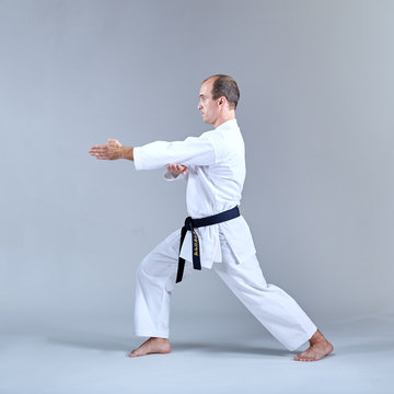 Sportsman with a black belt and karategi trains formal karate exercises Kaderov