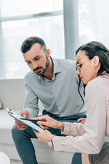 female psychiatrist talking with patient and showing clipboard in office