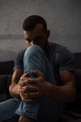 upset depressed man sitting at home, selective focus