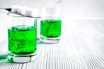 absinthe with sugar cubes and spoon on wooden background