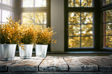 Wooden table and autumn background with window space 