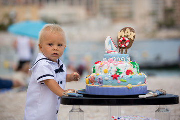 Sweet baby boy, celebrating first birthday with sea theme cake and decoration