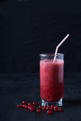 fresh smoothies of red currant in a glass stands on a black table