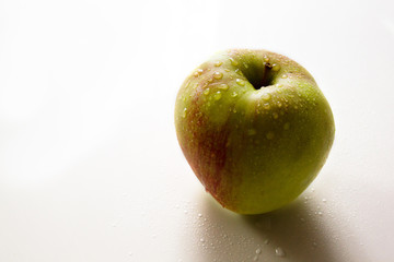 Green and red apple with drops of water