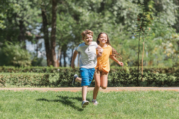 Fototapeta premium beautiful happy children running on grass in park
