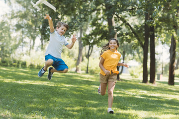 Obraz premium adorable happy children playing with plane model in park