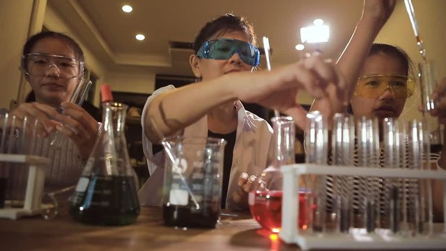 asian teacher and student in school science laboratory