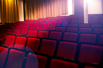 Auditorium in a theater or cinema, spotlights pass through empty seats