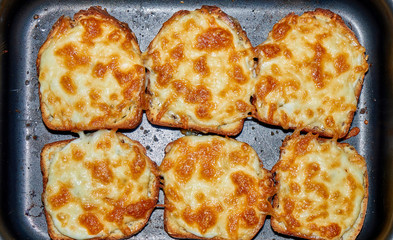 Fried bread with cheese and mayonnaise on the black tray