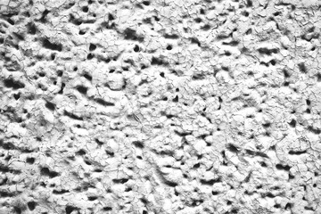 Detailed imperfect white texture of aerated foam block with holes close-up. Side of building is painted whitish. Background of construction from foamed material in macro. Decorative facing of house.