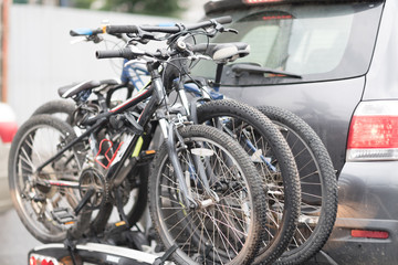 Fototapeta na wymiar car is transporting bicycles on rack. bikes on the trunk