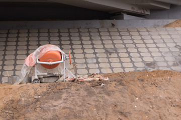 Underside of an elevated roads. Big hill with stone sheeld. concrete mixer portable