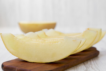 Sliced melon on rustic wooden board, side view. Close-up.