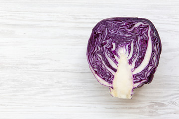 Half of red cabbage on white wooden background. From above, overhead, flat lay. Copy space and text...