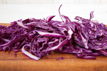 Chopped red cabbage on cutting board, close-up. Side view.