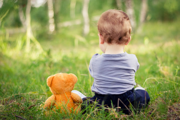 Little boy playing with brown Teddy bear