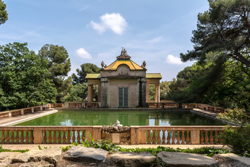 Fototapeta premium Neoclassical pavilion of Carlos IV and a square pond with fish in the Horta Labyrinth Park. The pavilion was built in 1794 by Domenico Bagutti.