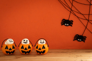 Halloween crafts, orange pumpkin, ghost and spider on wooden table and orange background with copy space for text. halloween concept. on wooden table and orange background with copy space for text