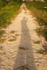 Shadow on man standing in the beach when sunset