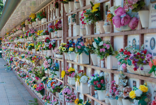 Loculi of a cemetery with many colored plastic flowers