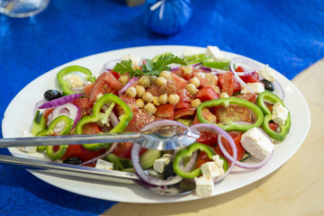 white plate with fresh salad. delicious summer vegetable flavor. natural light and a light grainy effect on a plateau of fresh vegetables and fresh food.