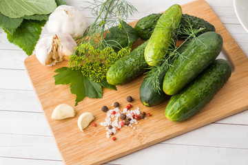 Marinated cucumbers, garlic and spices for salting on the wood surface.