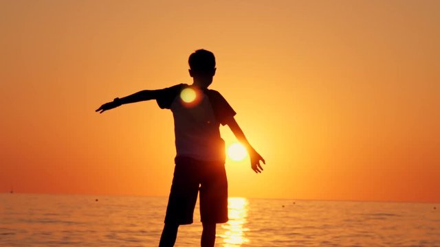 Silhouette of a boy standing on the beach, the concept of happiness, dream, human space, children's dream