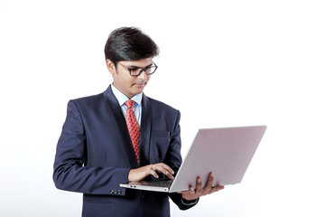 Young Indian businessmen using laptop over isolated background.