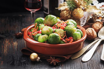Brussels sprouts with bacon, and caramelised onion on a black rustic table.