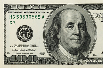 Part of the bill is one hundred US dollars. The left part. Close-up.