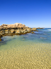 Fototapeta na wymiar Rocky shore and transparent waters at Praia da Galheta (Galheta beach) in Florianopolis, Brazil