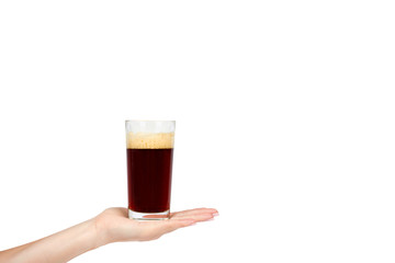 Hand with cold glass of dark beer or kvass with foam isolated on white background, copy space template.