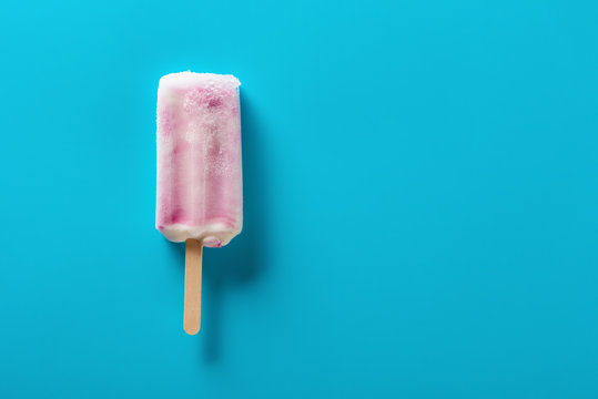 strawberry flavor popsicle on a blue background