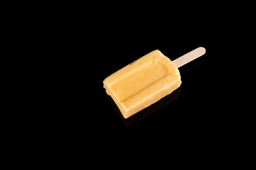 mango or orange flavor popsicle on black background