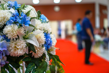 Artificial flowers decorated with red carpet.