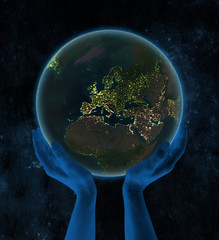 Slovenia on night Earth in hands in space