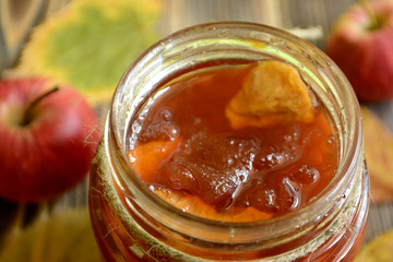 Apple jam in a jar on a wooden background