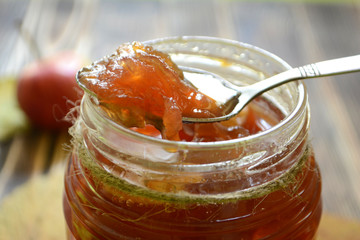 Apple jam in a jar on a wooden background