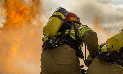 Some firemen fighting a great fire. Firefighters doing some training.