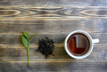 tea leaves, dried tea and tea in a cup on a wooden background tea concept
