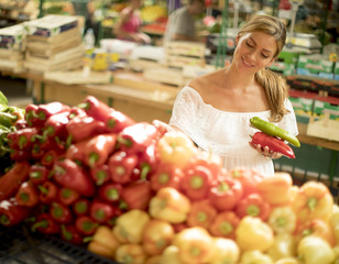 Young woman buying vegetables on the market