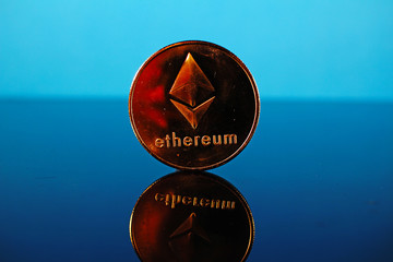 Etherum money crypto currency coin on reflective colorful background