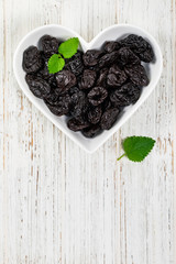 Dried Plums Pitted Prunes in Heart Shaped Bowl. Selective focus.