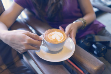 woman hands holding hot cup of coffee in morning. girl hold coffee mug in cafe.