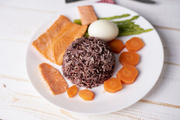 Health food concept, salmon with rice and vegetable on wood background