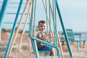 Obraz premium Child on a swing near the sea