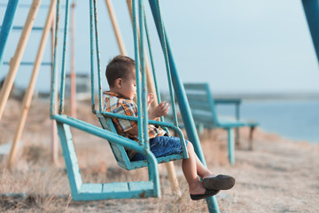 Child on a swing near the sea