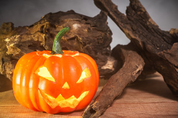 close-up of holloween pumpkin on wooden table, smoke float up on black background
